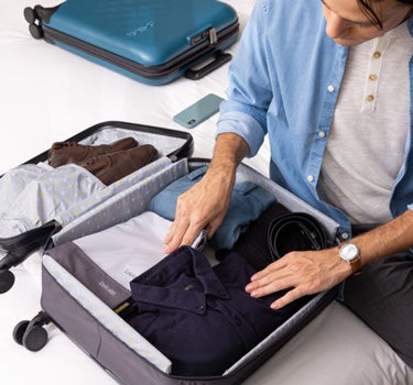 man packing carry-on luggage