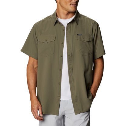 Man wearing a Columbia Men's Utilizer™ II Solid Short Sleeve Shirt in stone green colour. Shirt unbuttoned and wearing a white tee-shirt underneath.