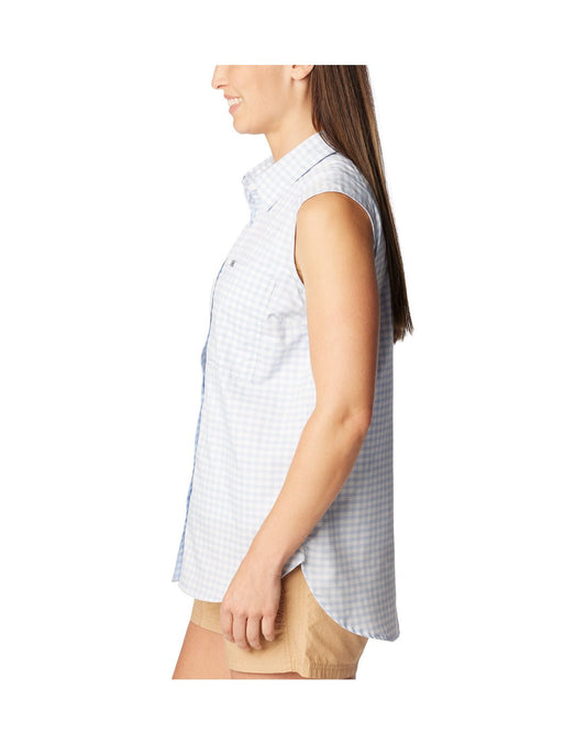 Product Image – Woman wearing beige shorts and Columbia Women's Anytime™ Lite Sleeveless Top in whisper light blue and white checkered pattern, side view