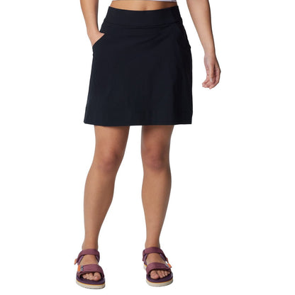 Bottom half of woman wearing purple sandals and Columbia Women's Anytime™ Straight Skort in black with one hand in pocket, front view