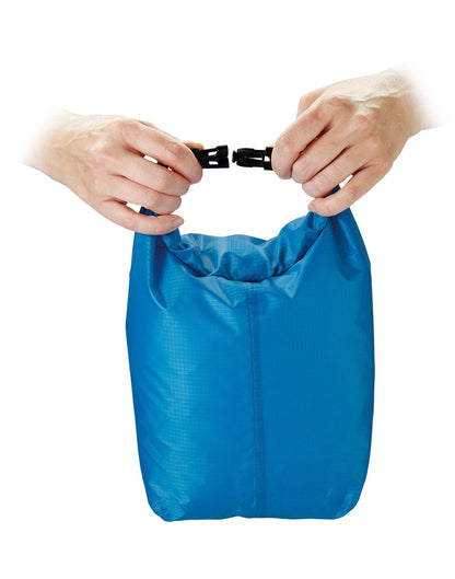 Front view of blue Go Travel Wet/Dry Bag with hands unbuckling strap.