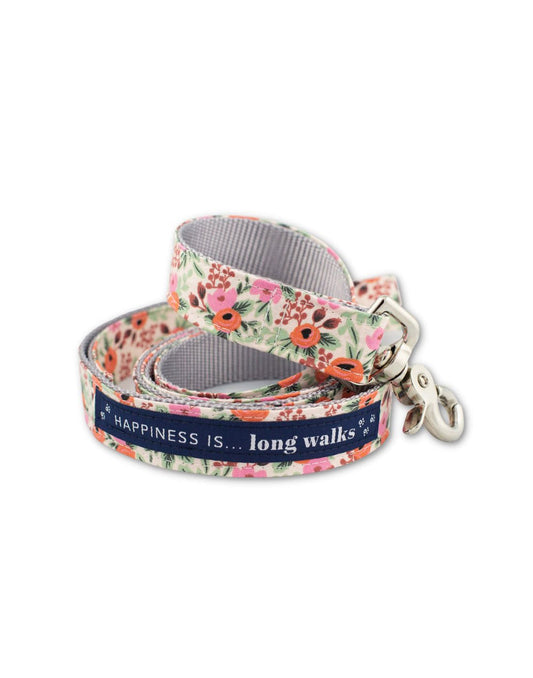 Product Image – Happiness Is... Long Walks Floral Dog Leash coiled up, with silver clip and navy blue strip with white small paw prints and words that read Happiness Is...long walks 