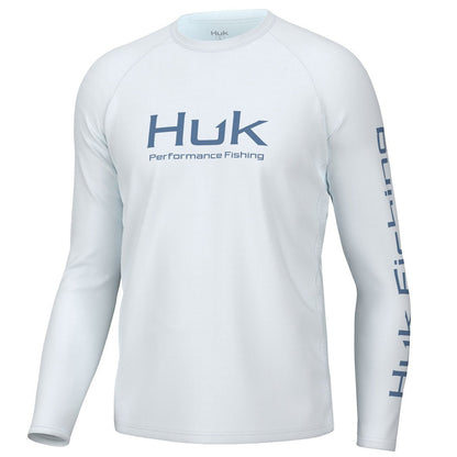 Front view of the Huk Men's Pursuit Performance Shirt  in white. Huk logo printed across chest and "Huk Fishing" along outside length of left sleeve.