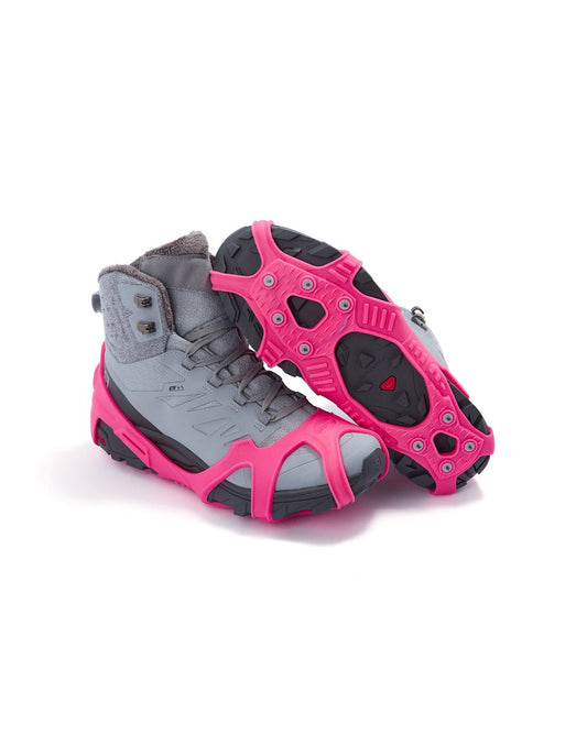 Product Image – Icetrax V3 Tungsten Ice Cleats in bright pink on a pair of grey hiking boots, side view, one boot is upturned to show bottom cleats