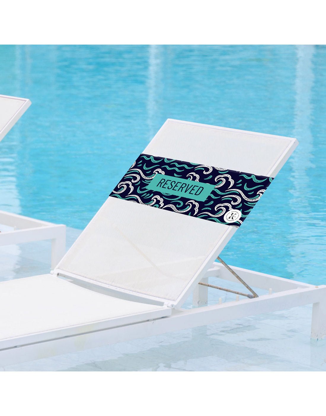 Lifestyle image of ocean K5 Reserved Chair Sleeve, placed on a poolside chair with pool visible in the background.