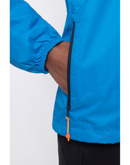 Close up of hands in pocket of ocean blue Mac in a Sac Origin II Packable Waterproof Jacket.