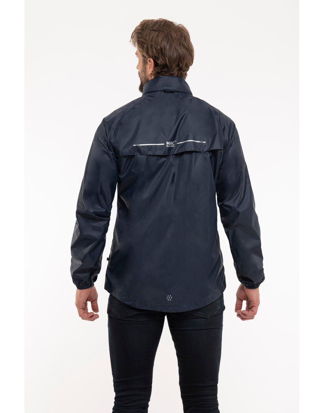 Man wearing Mac in a Sac Origin II Packable Waterproof Jacket in navy, back view.