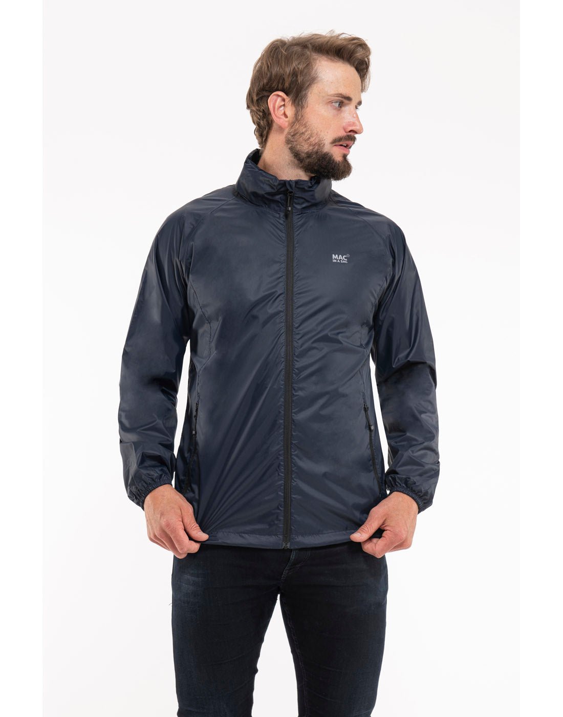 Man wearing Mac in a Sac Origin II Packable Waterproof Jacket in navy, front view with hands holding the bottom of the jacket.