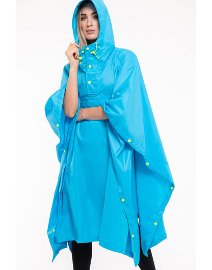 Woman wearing Mac in a Sac Packable Waterproof Poncho in neon blue, front angle view.