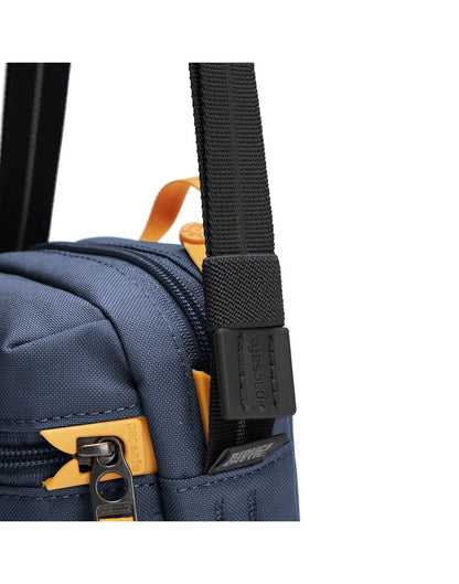 Pacsafe® GO Anti-Theft Micro Crossbody in coastal blue colour, close up  of cut resistant shoulder strap and zipper with dock lock.