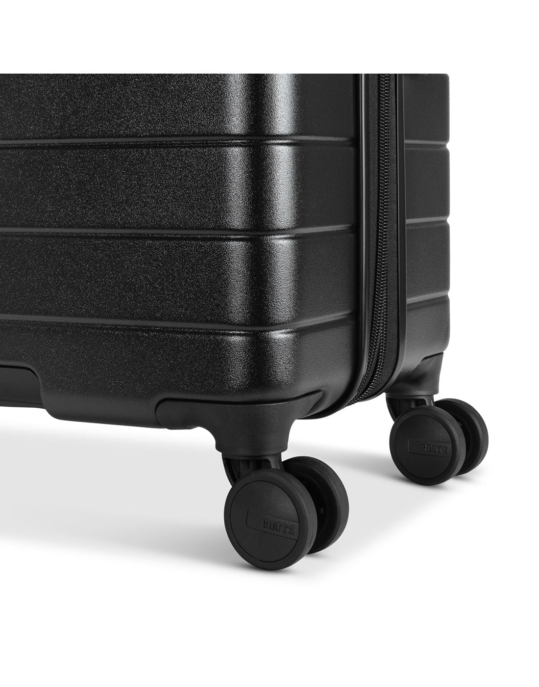 Roots Travel 28" Expandable Hardside Spinner in black, close-up view of spinner wheels.