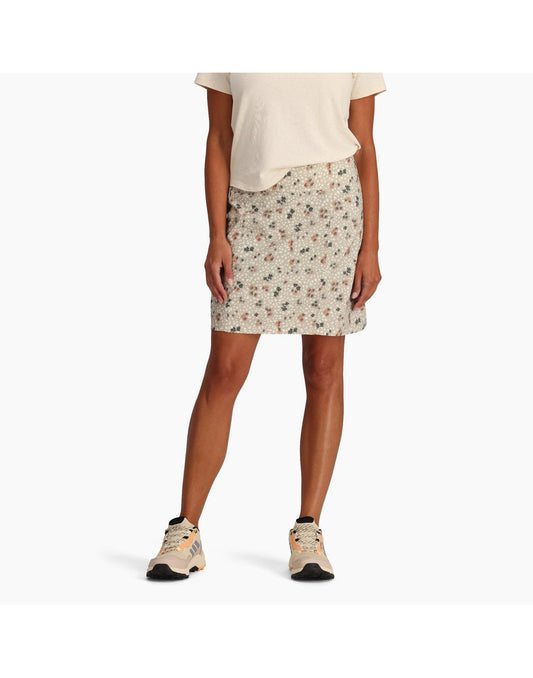 Product Image – Bottom half of woman wearing Royal Robbins Women's Discovery III Printed Skort in light khaki colour with off-white t-shirt and matching running shoes