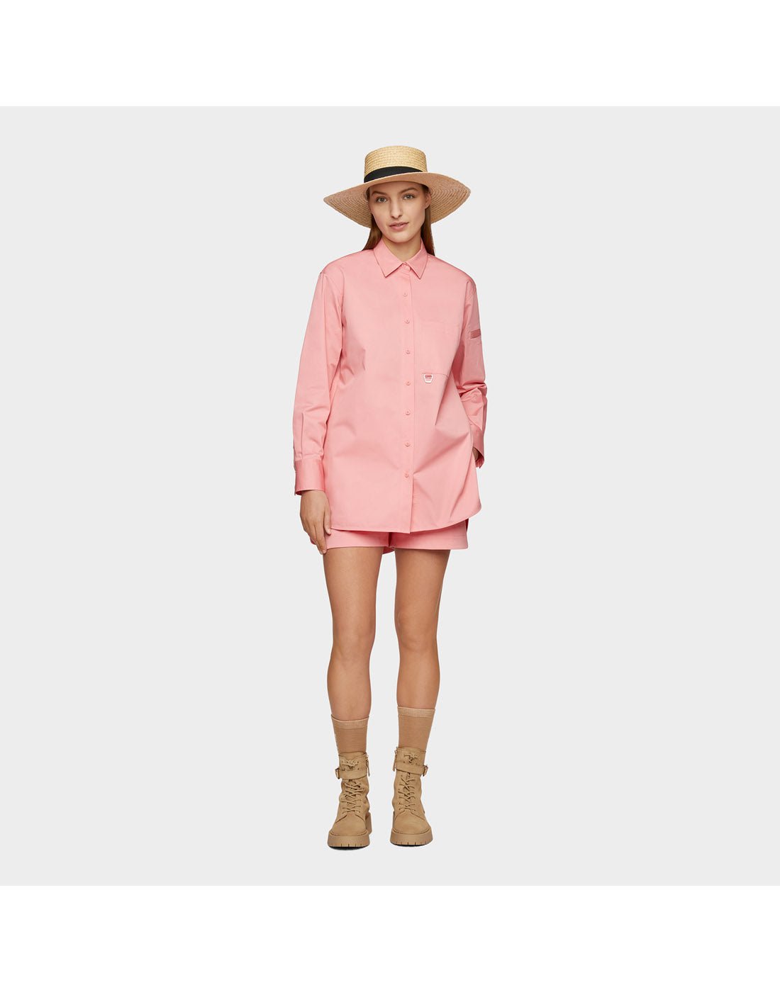 Woman wearing pink shirt and shorts and the Tilley Raffia Wide Brimmed Hat