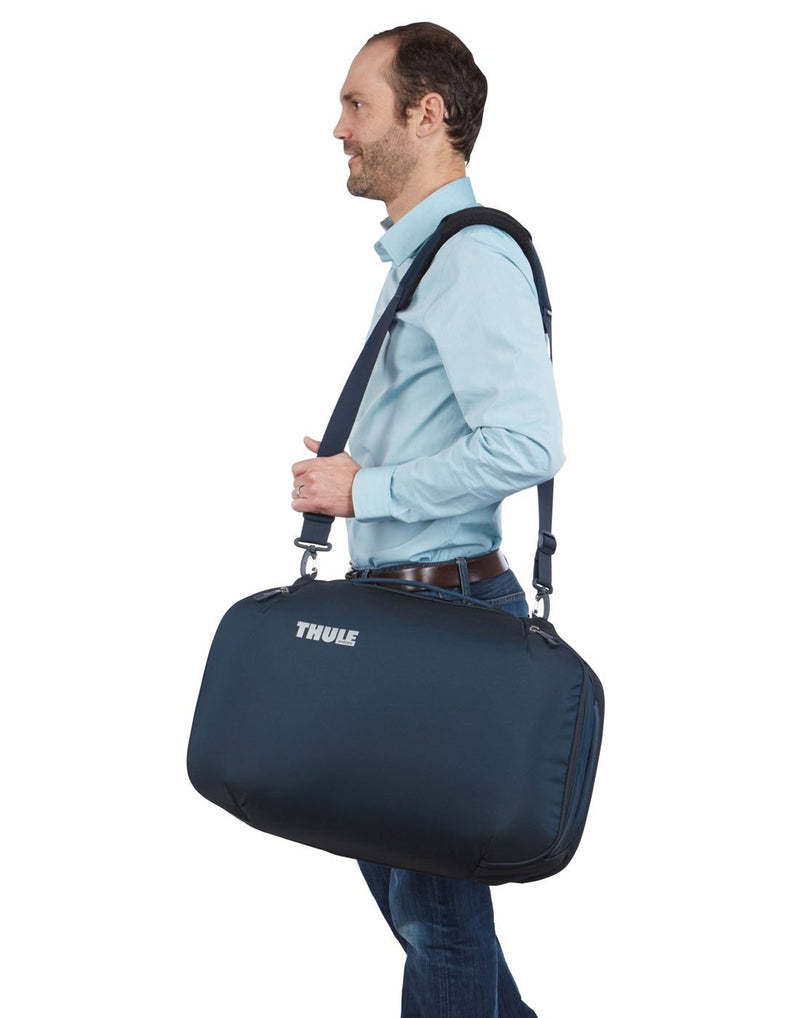 Man wearing Thule subterra carry-on 40L mineral colourbag using as shoulder bag