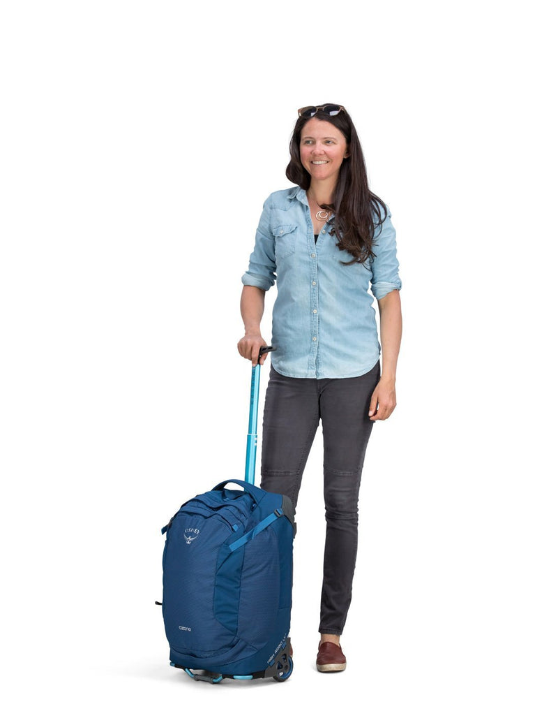 Women holding osprey ozone 42L/21.5" buoyant blue colour luggage bag body view