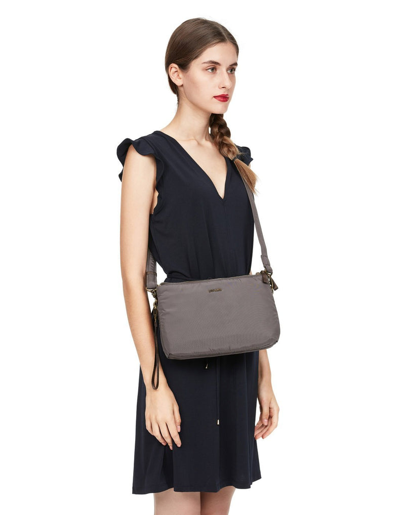 Women carrying pacsafe stylesafe anti-theft double zip mocha colour crossbody bag front view