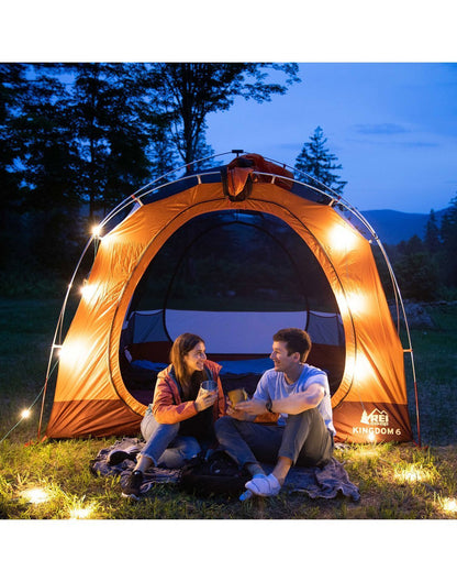 Luci Solar String Lights - lifestyle, on display attached to a tent with two people sitting in front