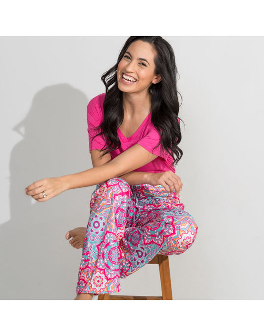 Product Image – Woman sitting on a stool wearing Howard's Essential V-Neck T-Shirt in fushsia and the Howard's Essential Lounge Pant in Mandala