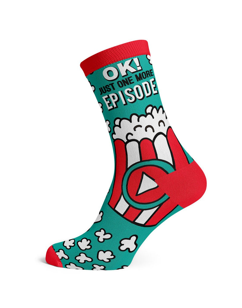 One green sock with red toe, heel and cuff with text OK! Just one more episode and a red and white box of popcorn and scattered popcorn design