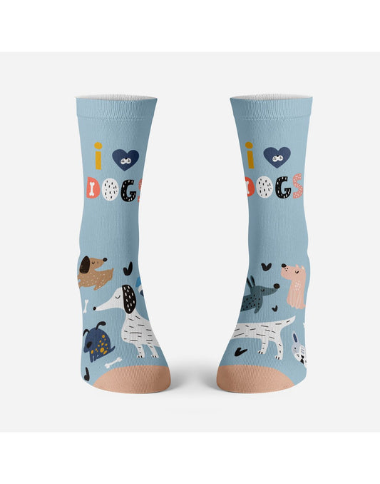 Product Image – Two light blue socks with peach toe with several dogs on each foot, one white with black ears, one light brown with dark brown ears, one dark blue with yellow spots, one pink with white spots, one dark blue with black spots.  White dog bones and black hearts around the dogs and on the ankle, colourful words i (heart symbol) DOGS