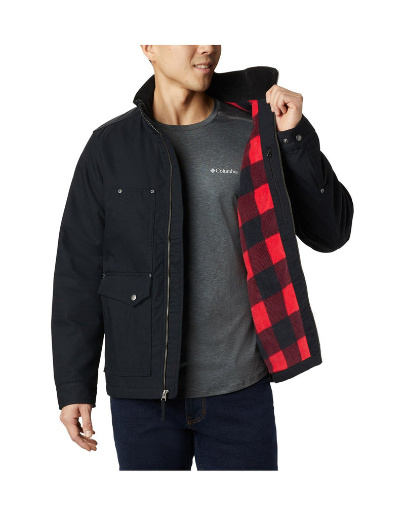 Man wearing black Columbia Men's Loma Vista™ Jacket, unzipped, holding one side open to show black and red checked liner