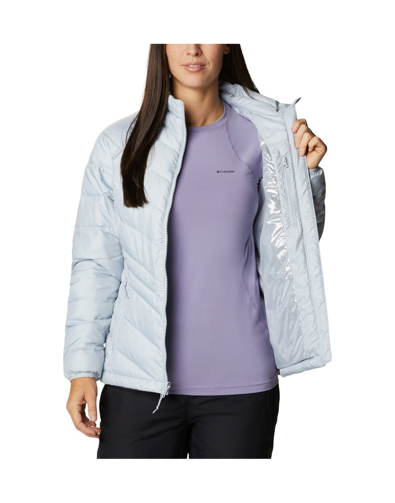 Woman wearing Columbia Women's Whirlibird™ IV Interchange Jacket, shell removed, lighter puff jacket, unzipped, front view with one side being held open to show interior