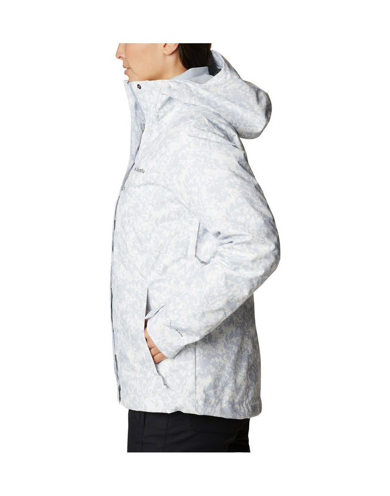 Woman wearing Columbia Women's Whirlibird™ IV Interchange Jacket in white florescence, side view, with hands in pockets