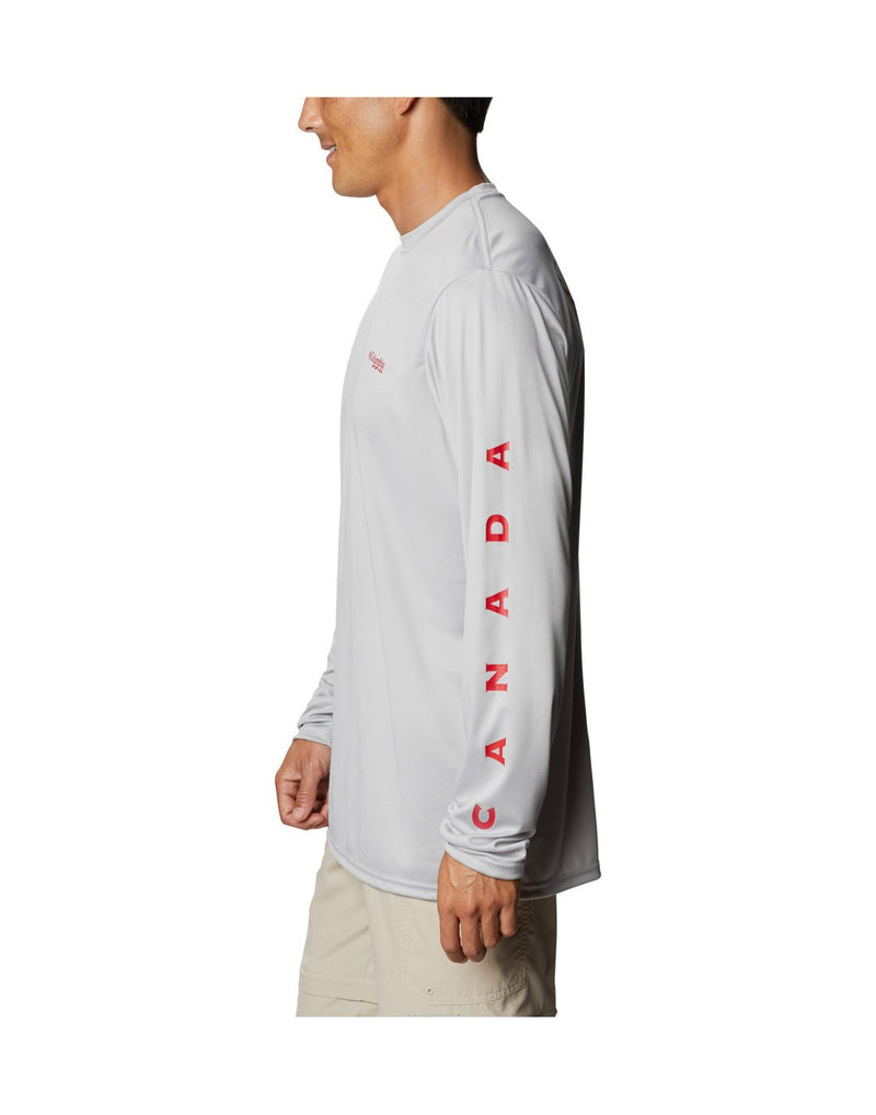 Model wearing Columbia Men's PFG Terminal Tackle™ Destination Long Sleeve Shirt - cool grey, side view showing "Canada" along left arm