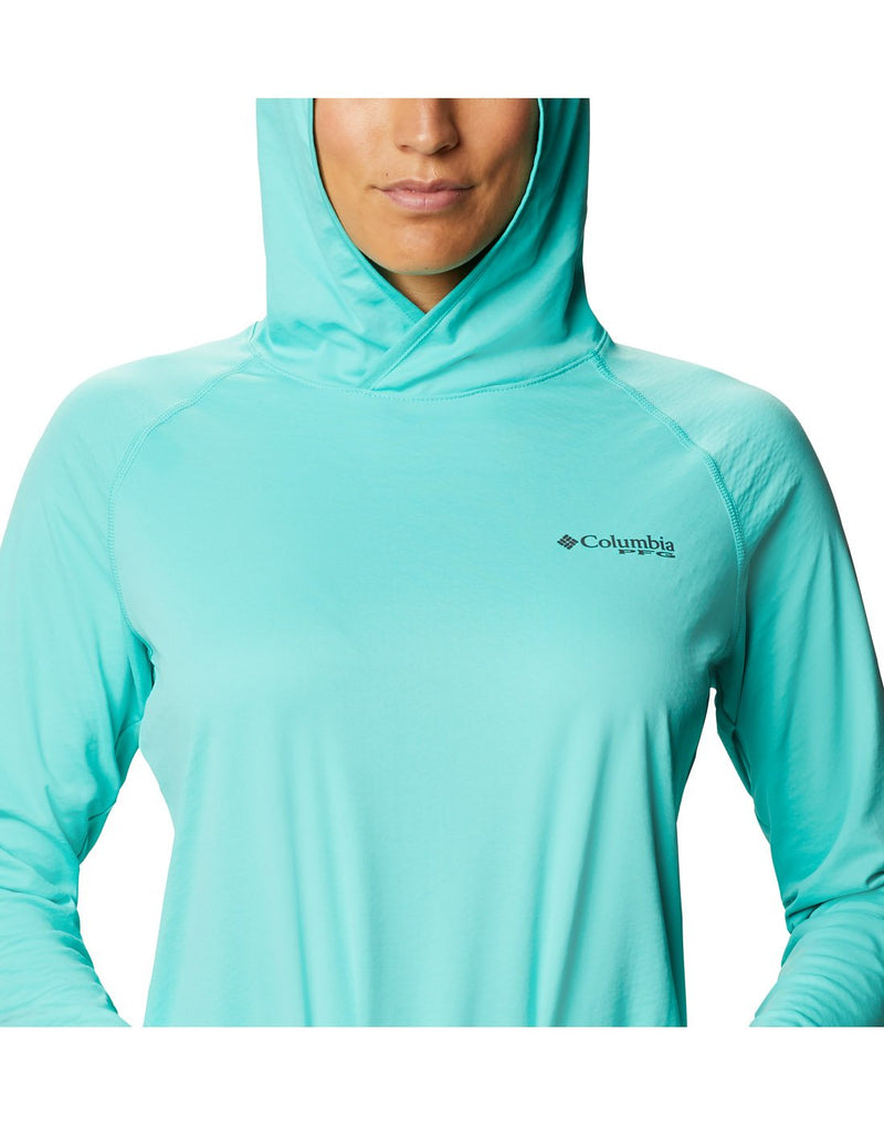 Close up of woman wearing Columbia Women's PFG ZERO Rules™ Ice Hoodie - dolphin colour, front view with black Columbia PFG logo on left breast