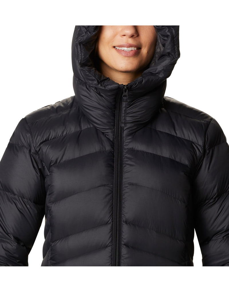 Close up of woman wearing Columbia Women's Autumn Park™ Down Hooded Mid Jacket in black, zipped up with hood up, front view