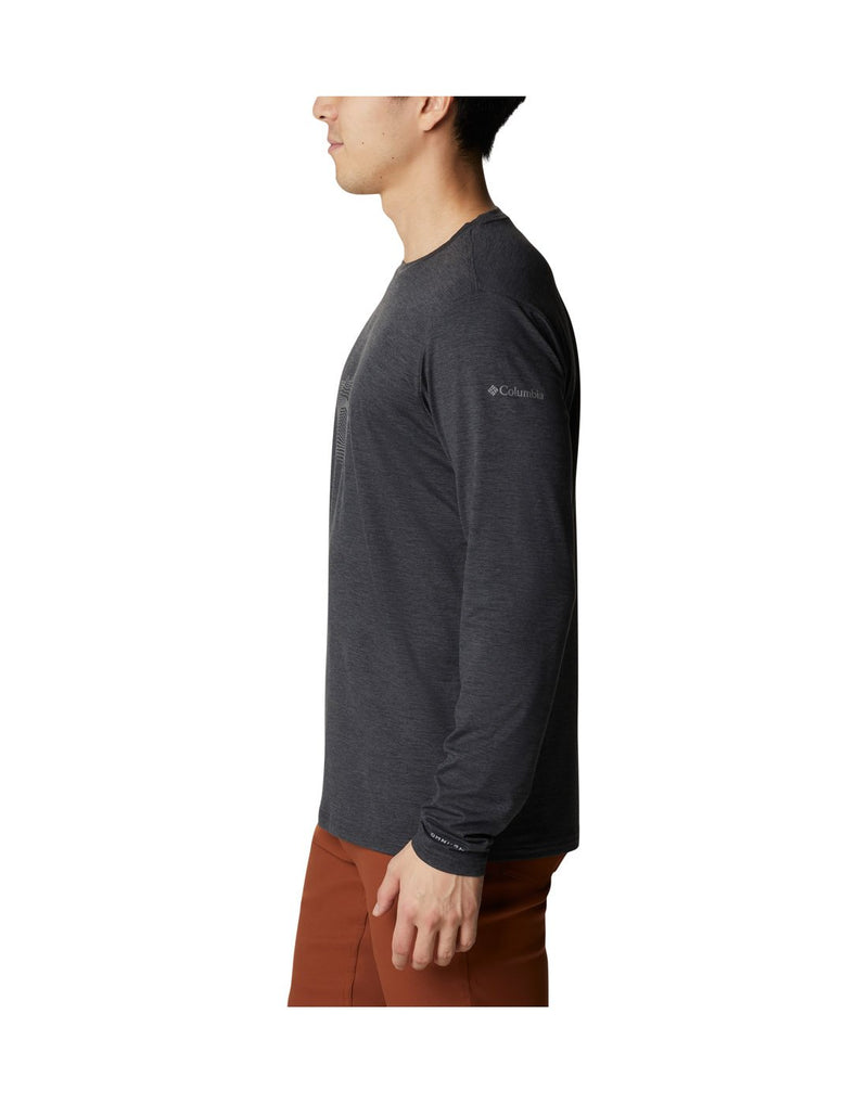 Man wearing Columbia Men's Tech Trail™ Long Sleeve Graphic T-Shirt in black heather, side view with Columbia logo on left shoulder