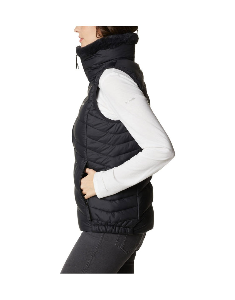 Woman wearing Columbia Women's Autumn Park™ Vest in black, zipped up, side view with hands in pockets