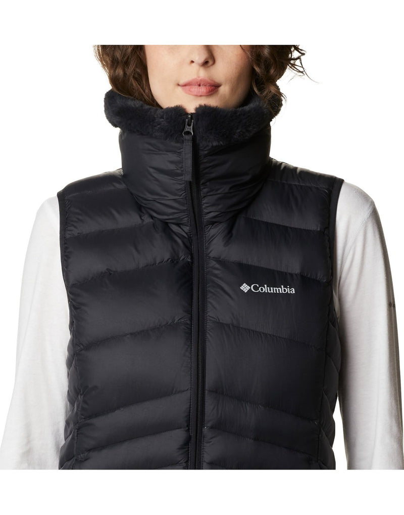 Close up of woman wearing Columbia Women's Autumn Park™ Vest in black, zipped up, front view, with Columbia logo on left chest