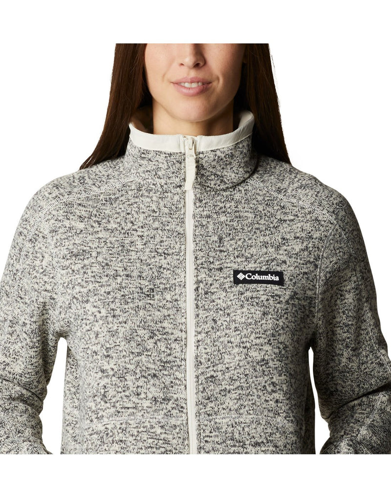 Close up of woman wearing Columbia Women's Sweater Weather™ Full Zip Jacket in chalk heather, zipped up, front view with Columbia logo on left chest