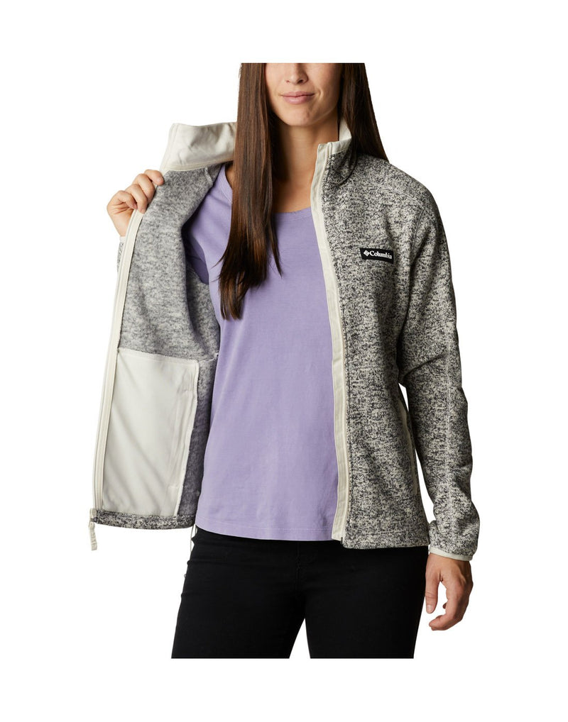 Woman wearing Columbia Women's Sweater Weather™ Full Zip Jacket in chalk heather, unzipped, front view, holding one side open to show interior