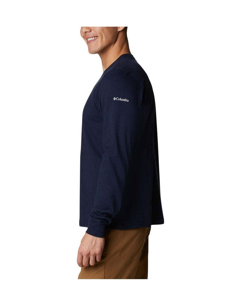 Man wearing Columbia Men's Apres Lifestyle™ Long Sleeve Graphic T-Shirt in collegiate navy colour, side view with Columbia logo on left shoulder