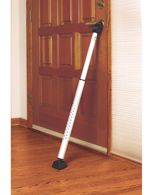 Product Image – Master Lock Security Bar installed on door knob of wooden entry door, leaning against wooden floor