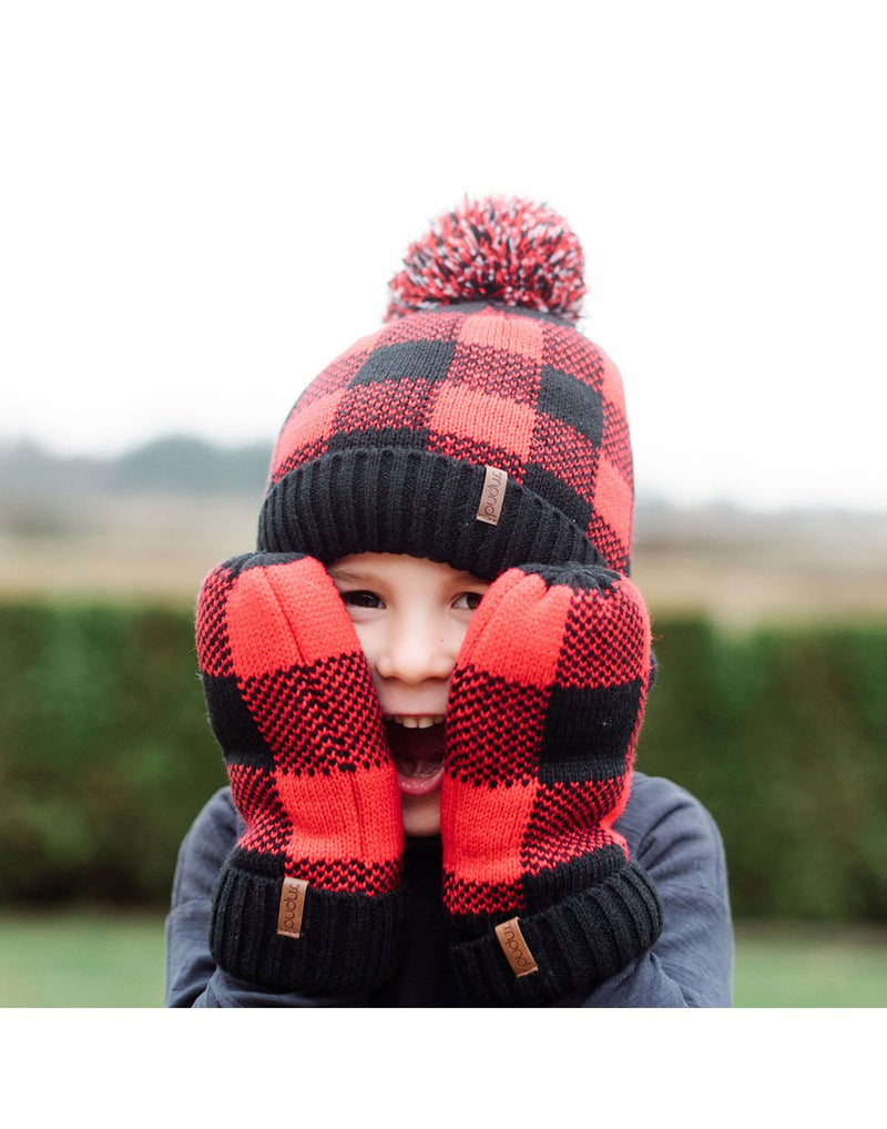 Child wearing Pudus Kids Toque Winter Hat and Mittens in Lumberjack Red holding hands up to face