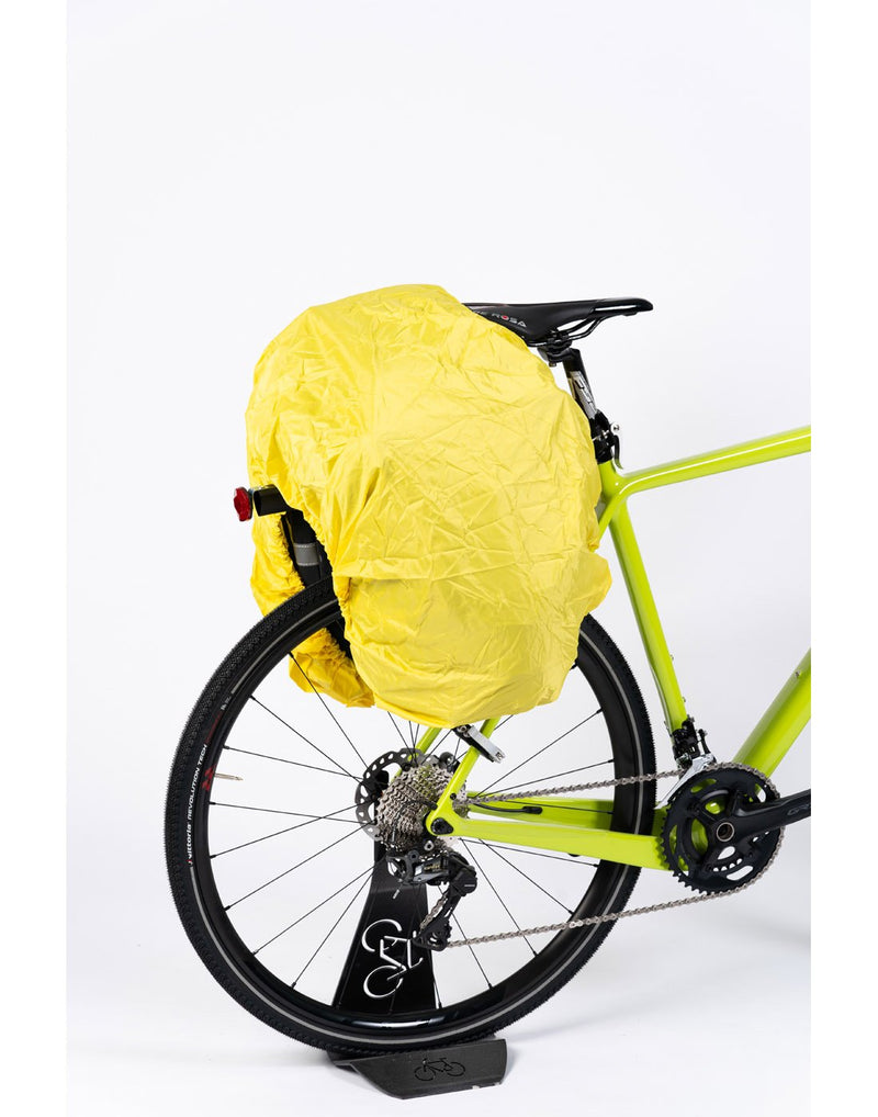 Corsino Discover 3-in-1 Pannier Bag - covered with yellow rain cover while attached to rear of a bicycle