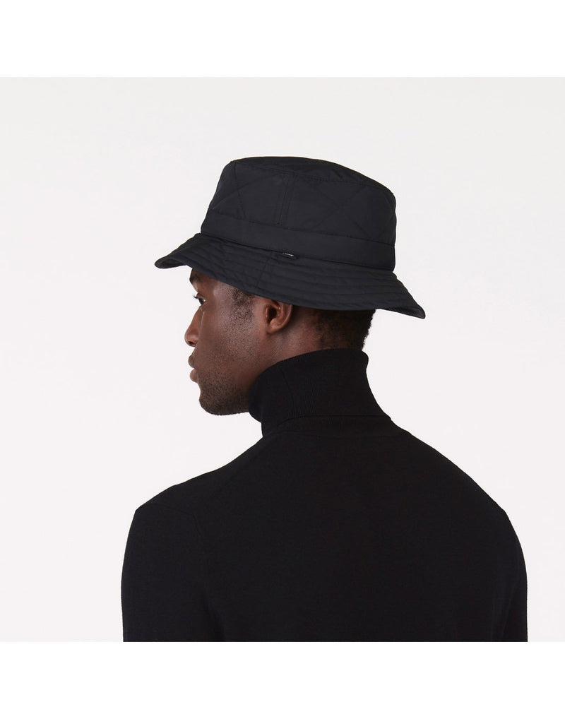 Man wearing a black turtleneck sweater and the Tilley Quilted Bucket Hat in black, back angled view
