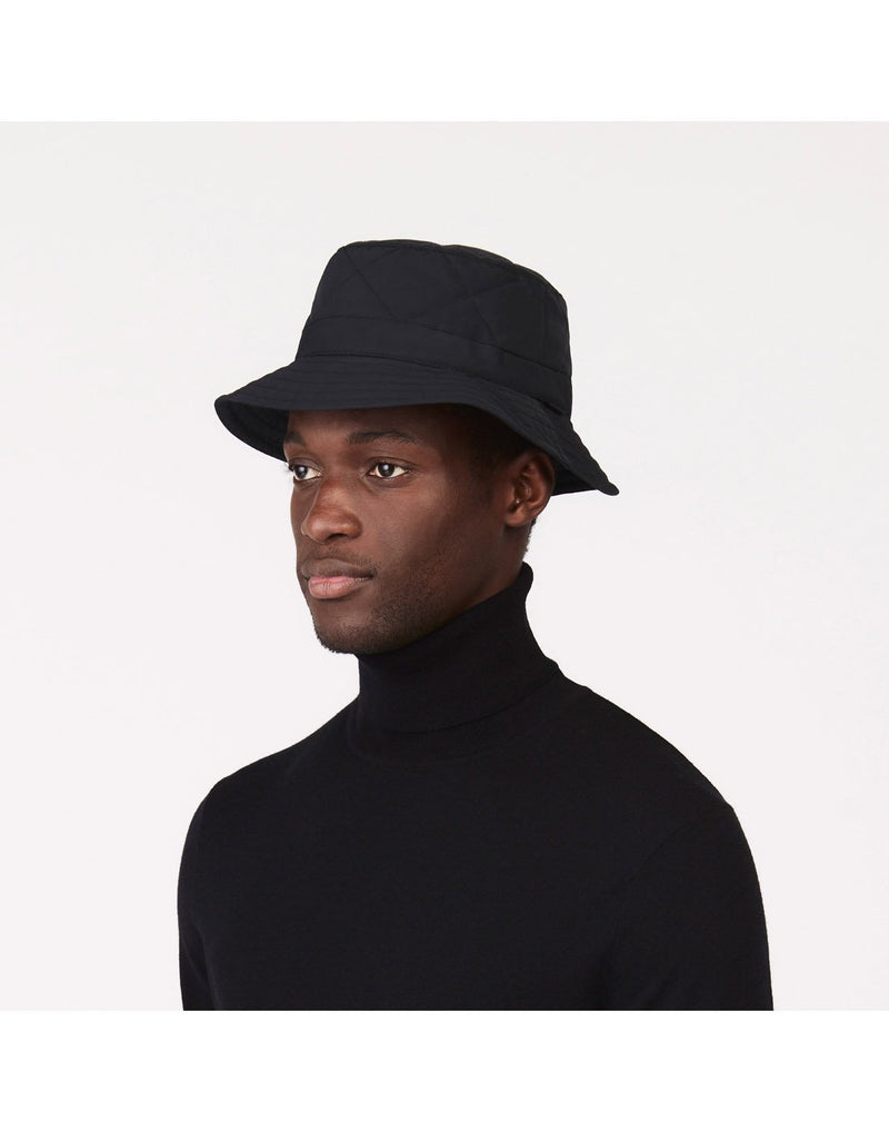 Man wearing a black turtleneck sweater and the Tilley Quilted Bucket Hat in black, front angled view