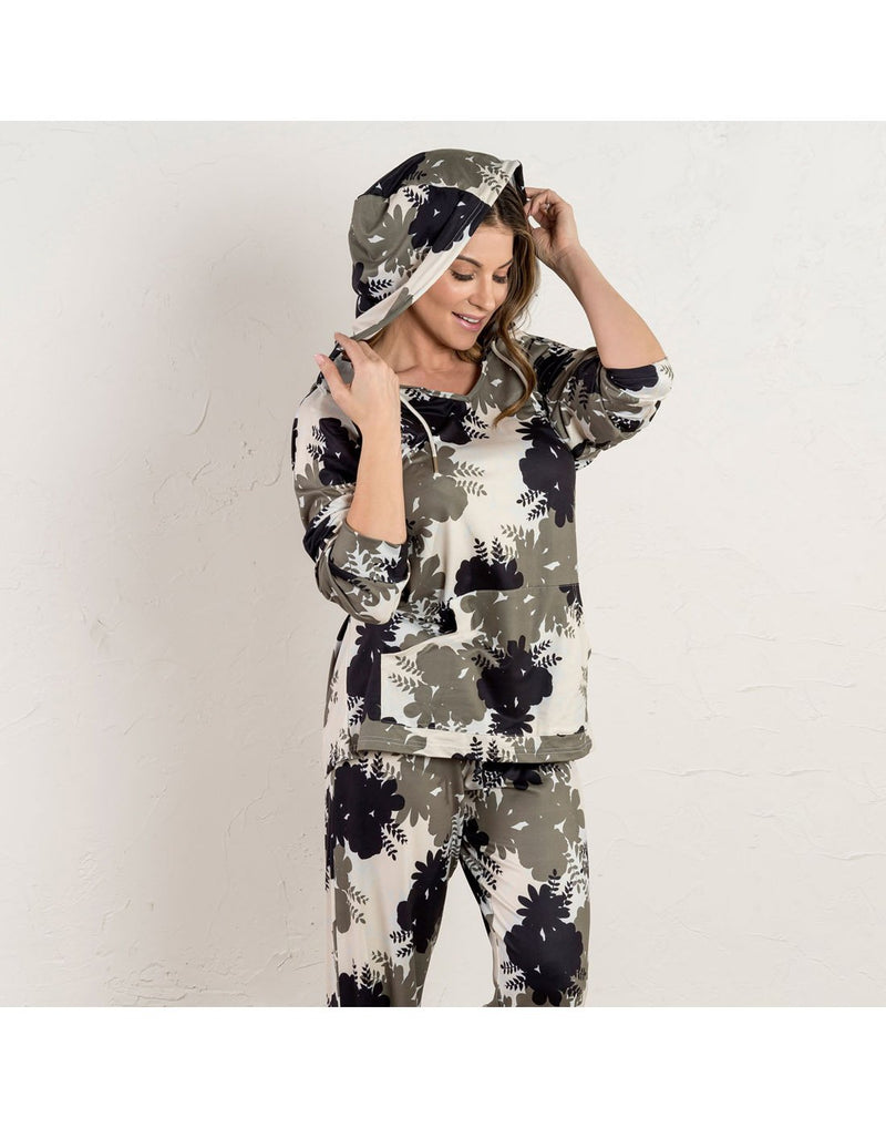 Woman wearing Howard's Floral Two-Piece Hooded Loungewear Set in Olive colour with green, white and black large floral pattern, holidng hood up and with sleeves scrunched up