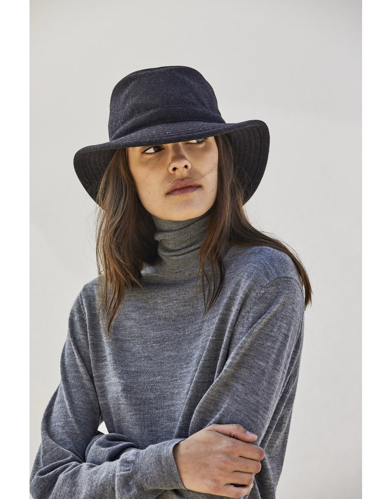Woman with long straight brown hair wearing a grey turtleneck and the Tilley TTW2 Tec Wool Hat in black with arms crossed