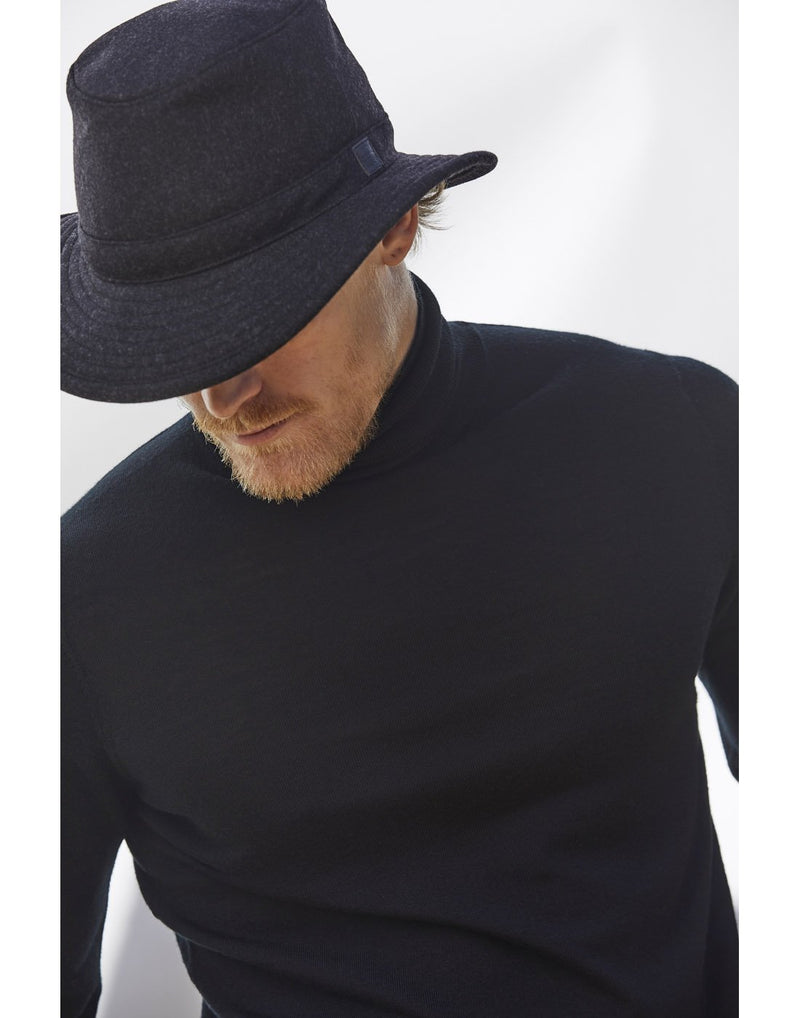 Man with light brown facial hair wearing a black turtleneck and the Tilley TTW2 Tec Wool Hat in black with head tilted down, hiding his eyes