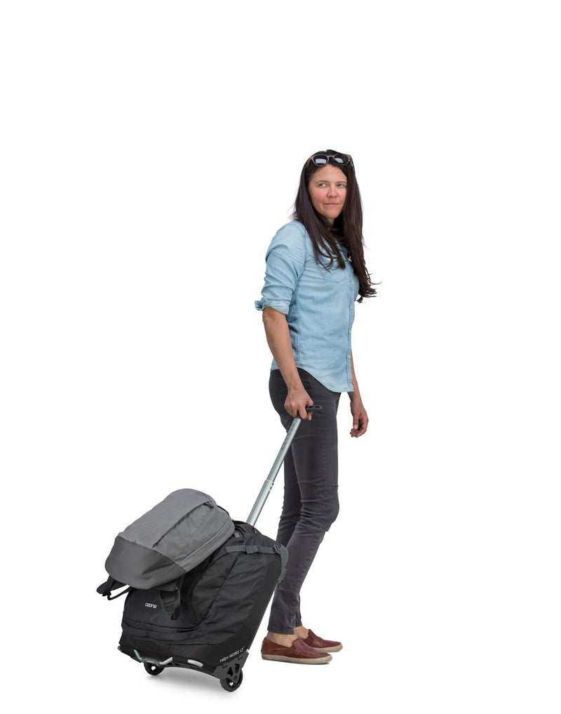 Women carrying osprey ozone 38L/19.5" global black colour luggage bag tuckaway tow bags