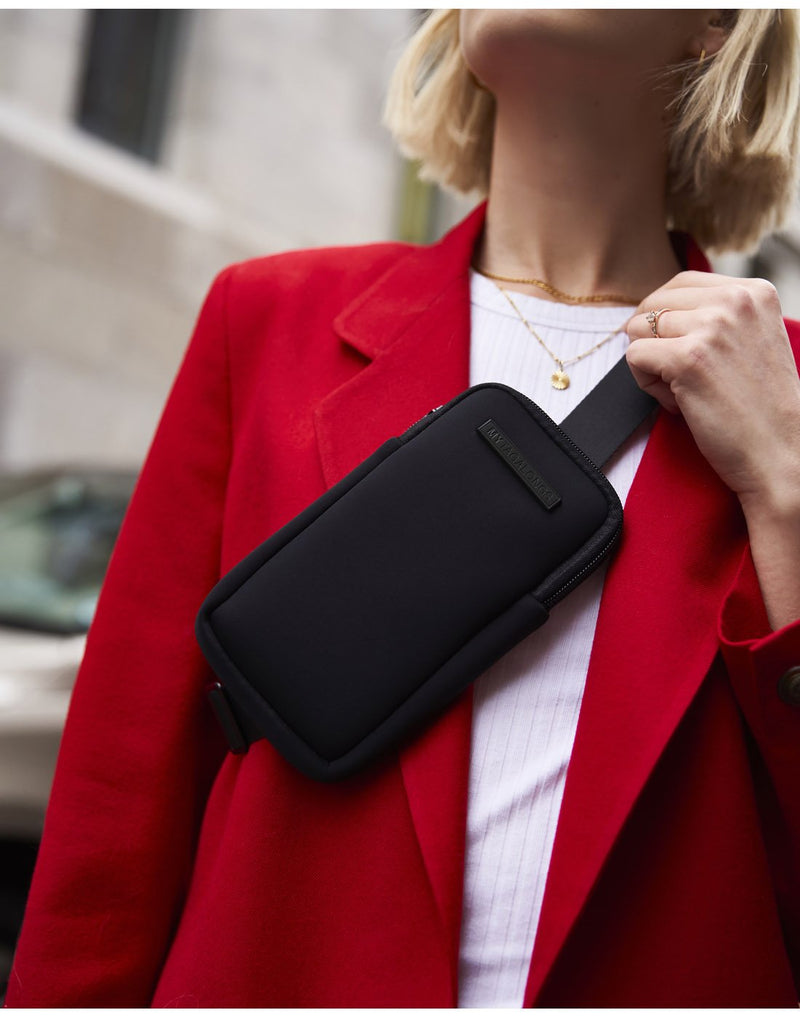 Woman wearing a red jacket and the MyTagAlongs phone sling crossbody across her chest