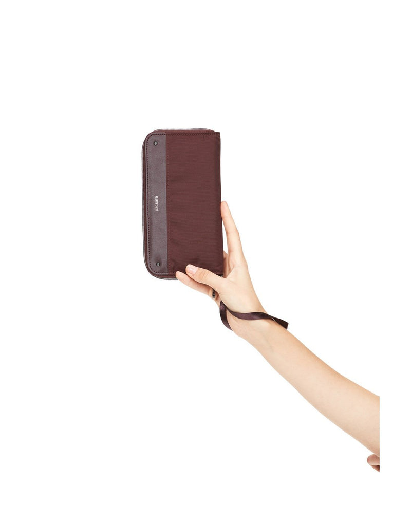 Women holding pacsafe RFID blocking merlot colour continental wallet front view