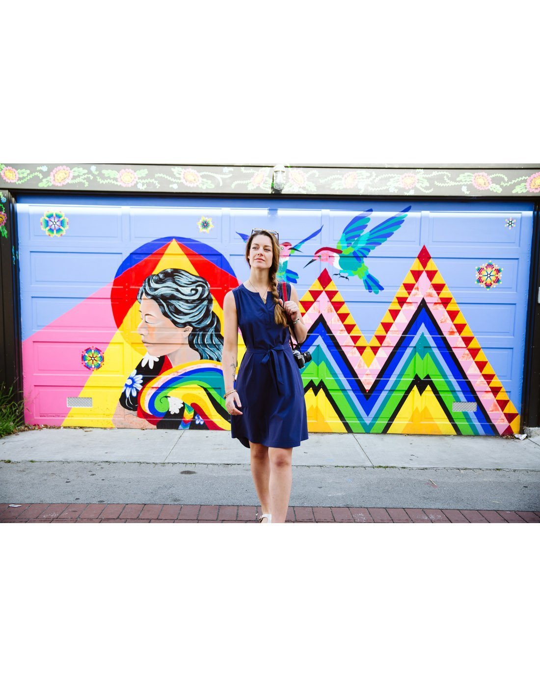 Women wearing Royal Robbins Women's Spotless Traveller Tank Dress - stellar, walking in front of a painted garage door