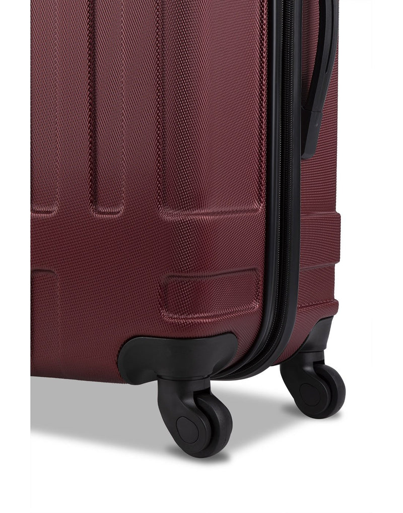 Close up of oxblood colour luggage spinner wheels