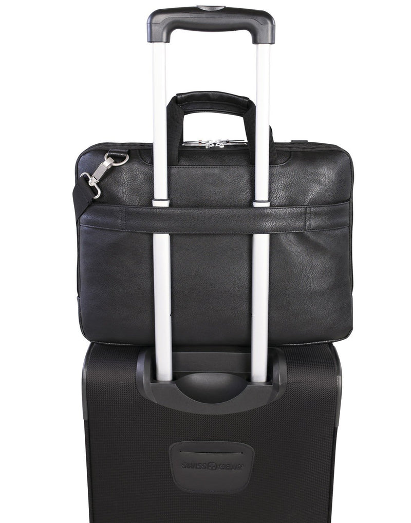 Swiss Gear Top Load Messenger Bag in black, back view, attached to a telescopic handle of a black carry-on luggage